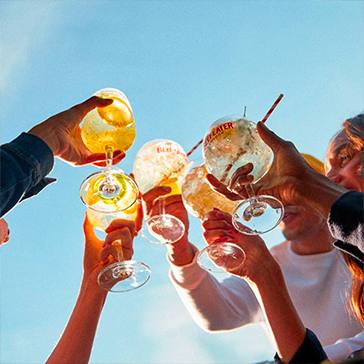 Verres de cocktails levés pour un toast festif, bar Le Petit Poucet Saint-Léon