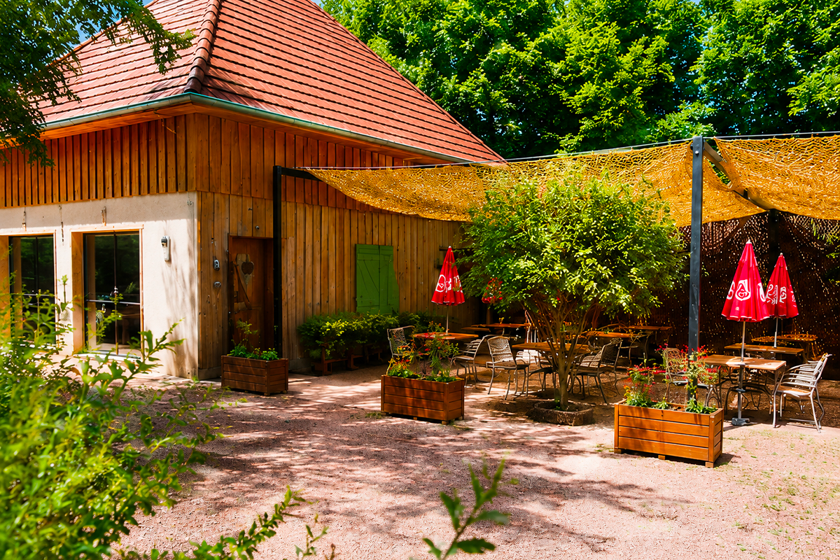 Chalet en bois du domaine Le Petit Poucet avec terrasse et parasols rouges, Saint-Léon