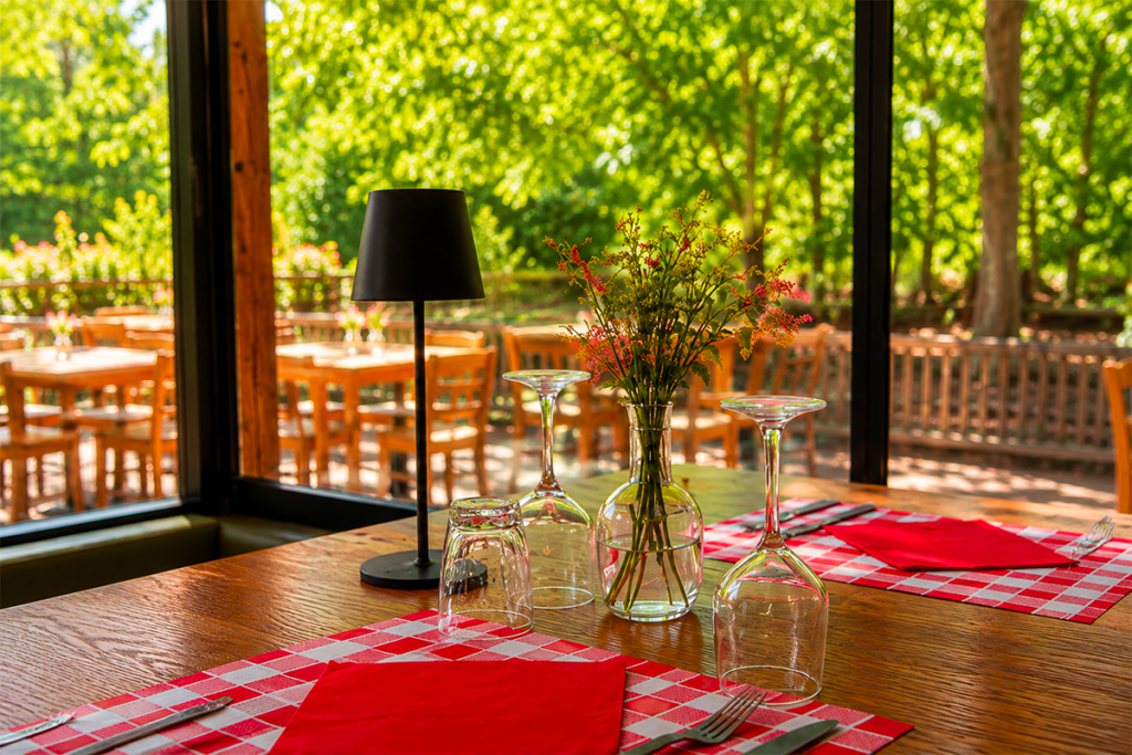 Allée ombragée du domaine Le Petit Poucet avec tables dressées et végétation, Saint-Léon