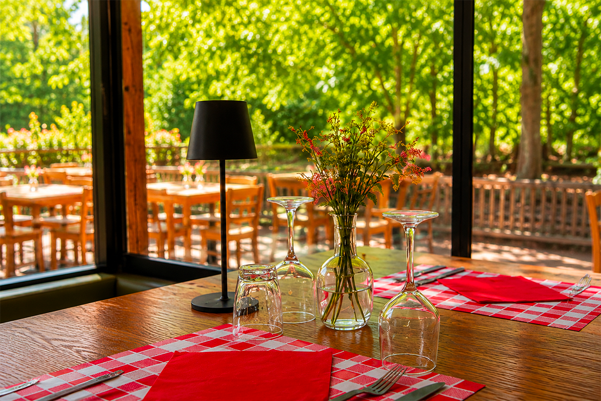 Allée ombragée du domaine Le Petit Poucet avec tables dressées et végétation, Saint-Léon