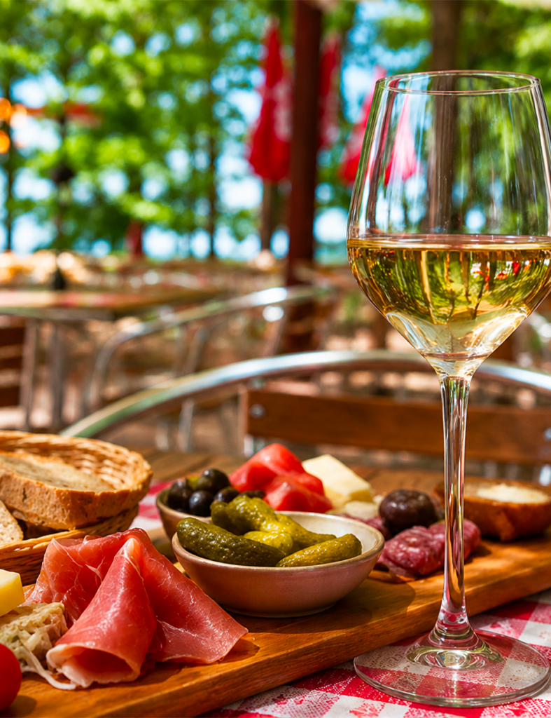 Verre de vin blanc au premier plan sur la terrasse du Petit Poucet, Saint-Léon